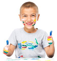 Image showing Portrait of a cute boy playing with paints