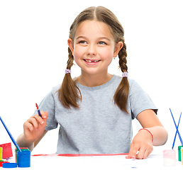 Image showing Little girl is painting with gouache