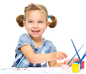 Image showing Little girl is painting with gouache