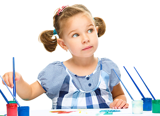 Image showing Little girl is painting with gouache