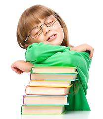 Image showing Little girl is sleeping on her books