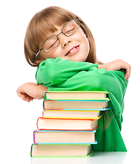 Image showing Little girl is sleeping on her books