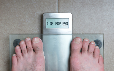 Image showing Man\'s feet on weight scale - Time for gym