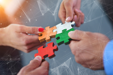 Image showing Group of business people assembling jigsaw puzzle