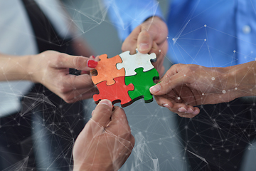 Image showing Group of business people assembling jigsaw puzzle