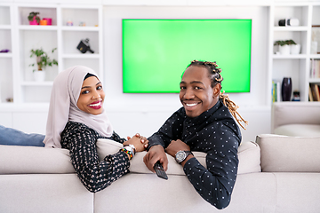 Image showing African Couple Sitting On Sofa Watching TV Together