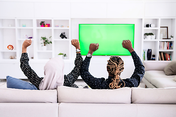 Image showing African Couple Sitting On Sofa Watching TV Together