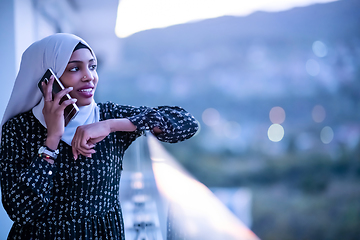 Image showing Young Muslim woman on  street at night using phone