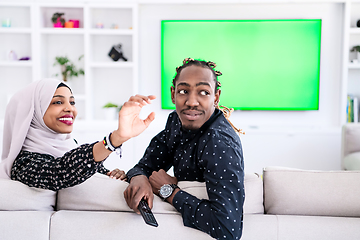 Image showing African Couple Sitting On Sofa Watching TV Together