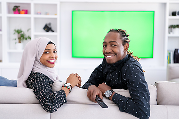 Image showing African Couple Sitting On Sofa Watching TV Together