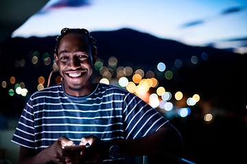 Image showing Young  Afro man on  street at night using phone