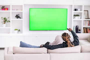 Image showing African Couple Sitting On Sofa Watching TV Together