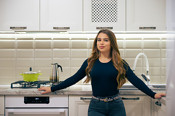 Image showing Young woman at luxury white classic kitchen interior