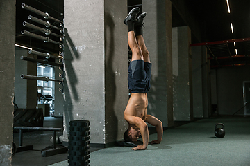 Image showing A muscular male athlete doing workout at the gym