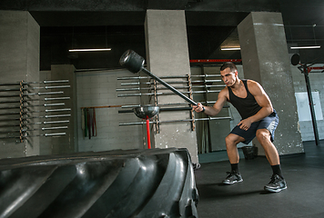 Image showing A muscular male athlete doing workout at the gym