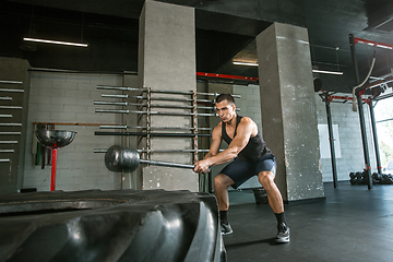 Image showing A muscular male athlete doing workout at the gym