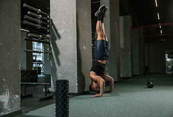 Image showing A muscular male athlete doing workout at the gym