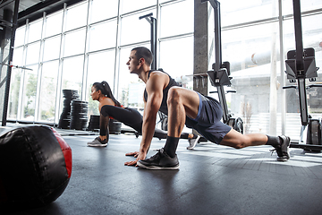 Image showing A muscular athletes doing workout at the gym