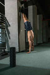 Image showing A muscular male athlete doing workout at the gym