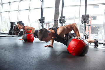 Image showing A muscular athletes doing workout at the gym