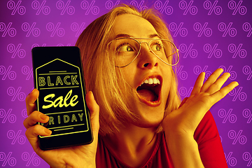 Image showing Portrait of woman showing screen of mobile phone, black friday