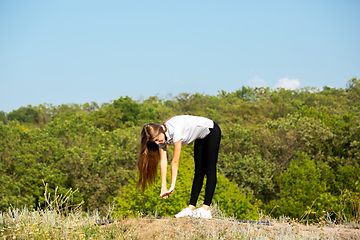 Image showing Beautiful young woman training flexibility outdoors