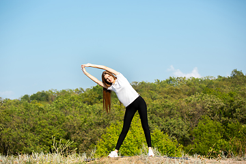 Image showing Beautiful young woman training flexibility outdoors