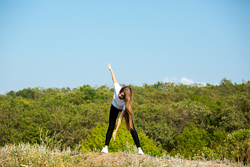 Image showing Beautiful young woman training flexibility outdoors