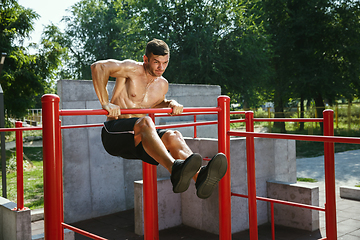 Image showing Young muscular man while doing his workout outside at playground