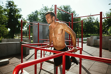 Image showing Young muscular man while doing his workout outside at playground