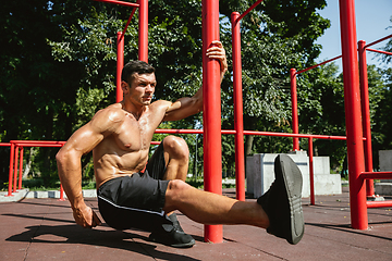 Image showing Young muscular man while doing his workout outside at playground