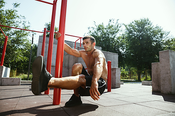 Image showing Young muscular man while doing his workout outside at playground