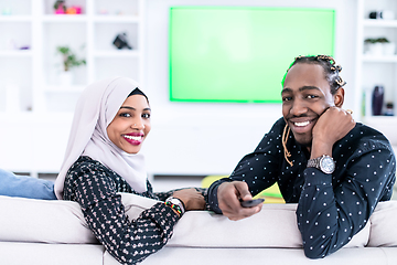 Image showing African Couple Sitting On Sofa Watching TV Together