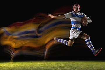 Image showing One caucasian man playing rugby on the stadium in mixed light