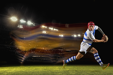 Image showing One caucasian man playing rugby on the stadium in mixed light