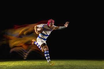 Image showing One caucasian man playing rugby on the stadium in mixed light