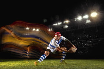 Image showing One caucasian man playing rugby on the stadium in mixed light