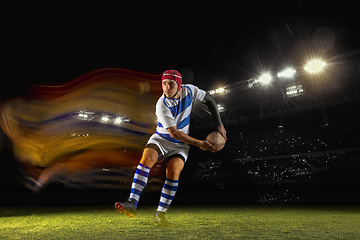 Image showing One caucasian man playing rugby on the stadium in mixed light