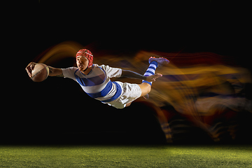 Image showing One caucasian man playing rugby on the stadium in mixed light