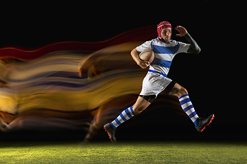 Image showing One caucasian man playing rugby on the stadium in mixed light