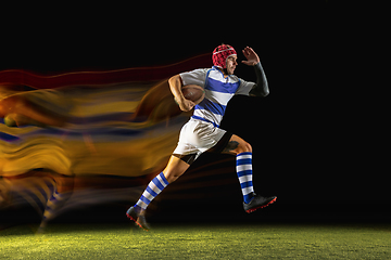 Image showing One caucasian man playing rugby on the stadium in mixed light