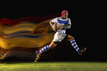 Image showing One caucasian man playing rugby on the stadium in mixed light