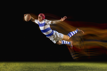 Image showing One caucasian man playing rugby on the stadium in mixed light