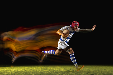 Image showing One caucasian man playing rugby on the stadium in mixed light