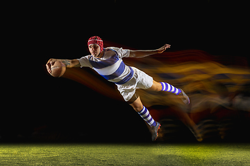 Image showing One caucasian man playing rugby on the stadium in mixed light