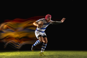 Image showing One caucasian man playing rugby on the stadium in mixed light