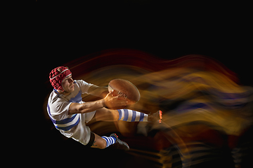 Image showing One caucasian man playing rugby on the stadium in mixed light