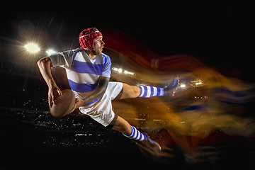 Image showing One caucasian man playing rugby on the stadium in mixed light