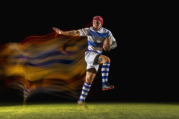 Image showing One caucasian man playing rugby on the stadium in mixed light