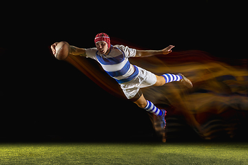 Image showing One caucasian man playing rugby on the stadium in mixed light